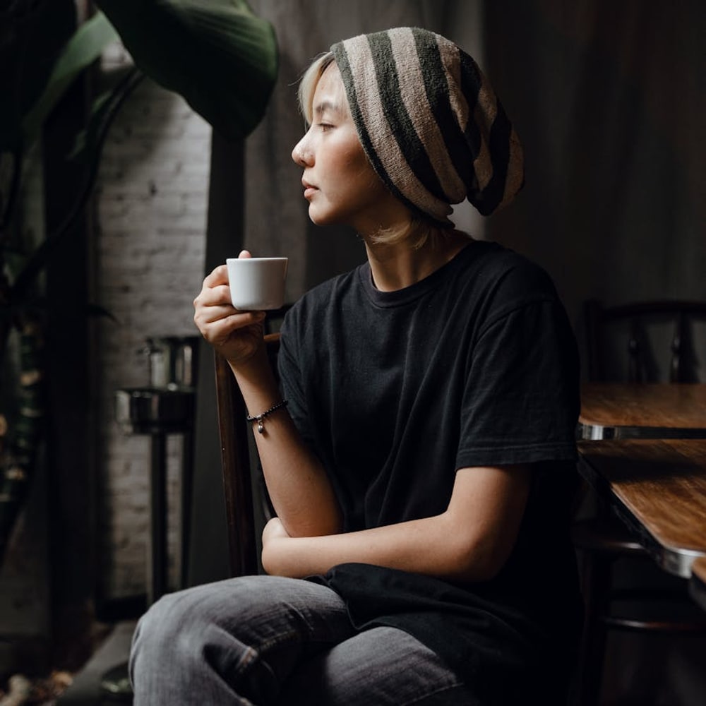 Solo woman enjoying coffee at a quiet café table with natural light