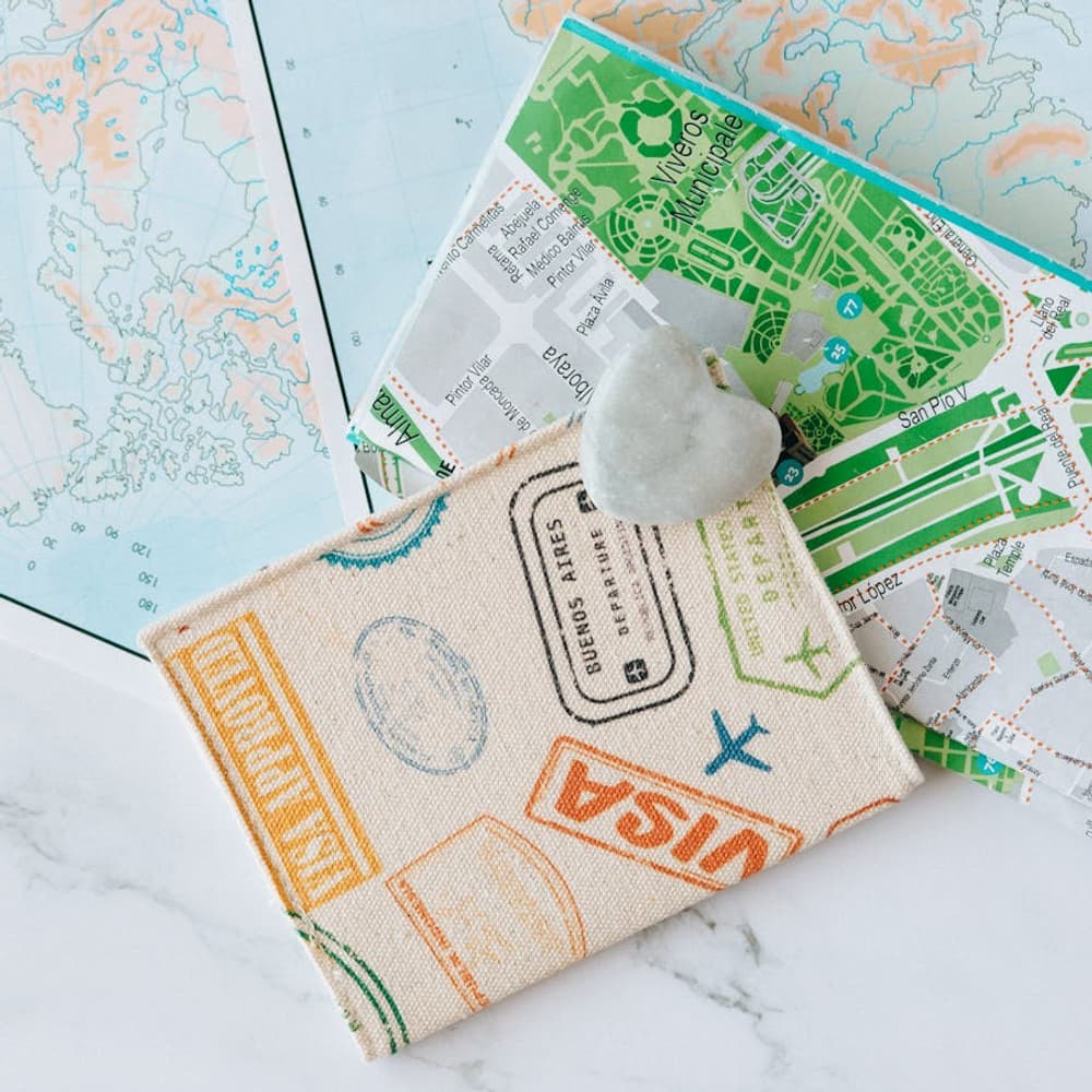 Traveler planning a trip with world map, passport, and compass on a wooden table