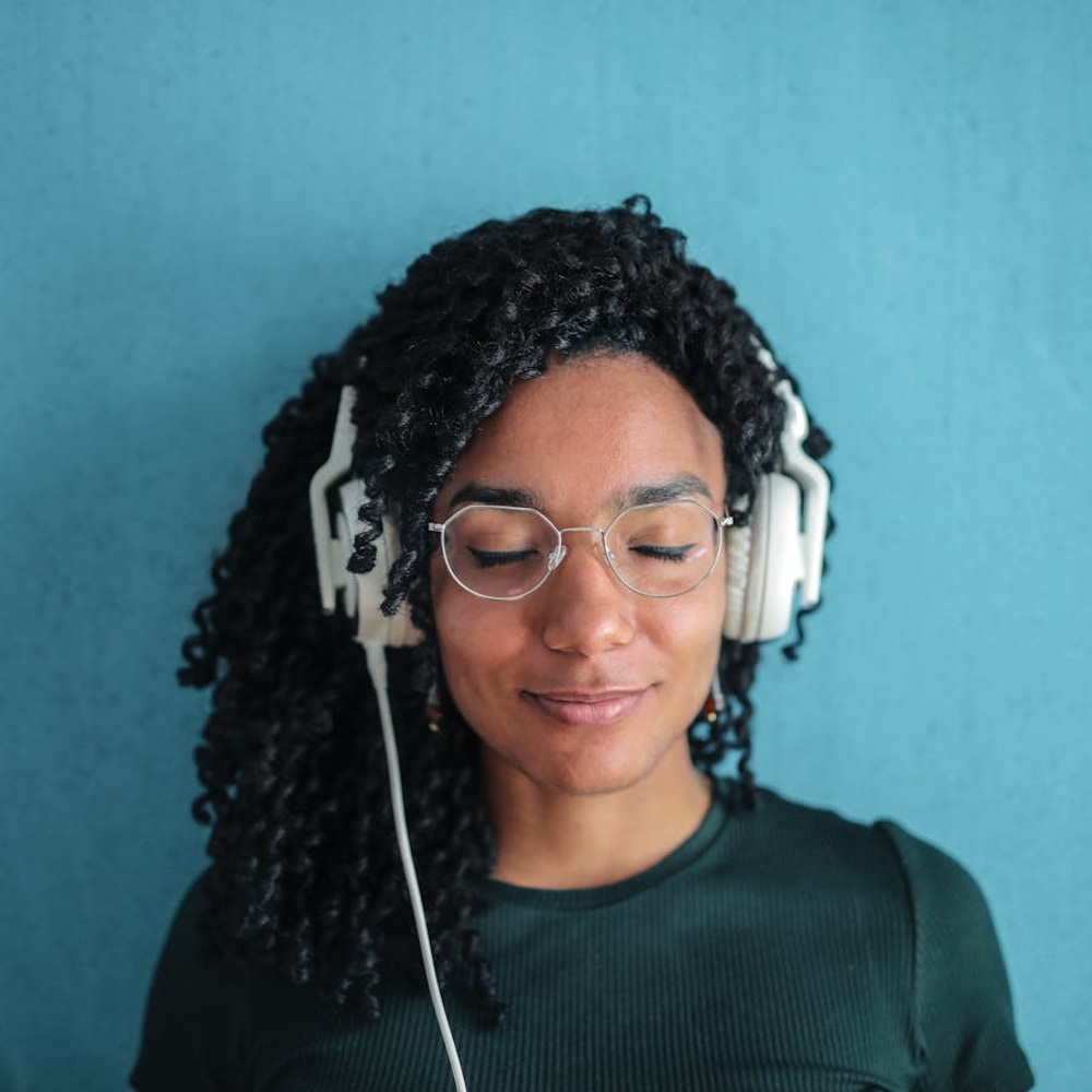 Smiling woman wearing white over-ear noise-canceling headphones