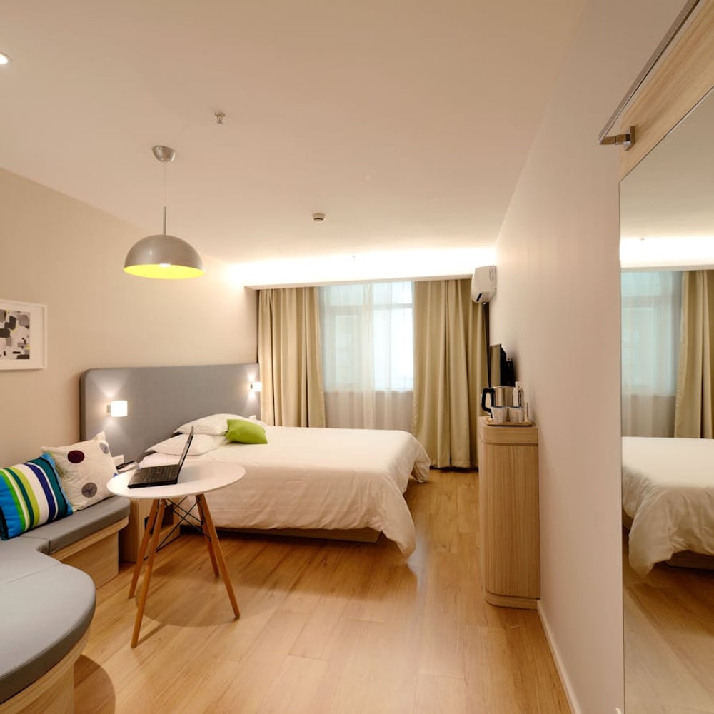 Simple affordable hotel room interior with comfortable bed and nightstand