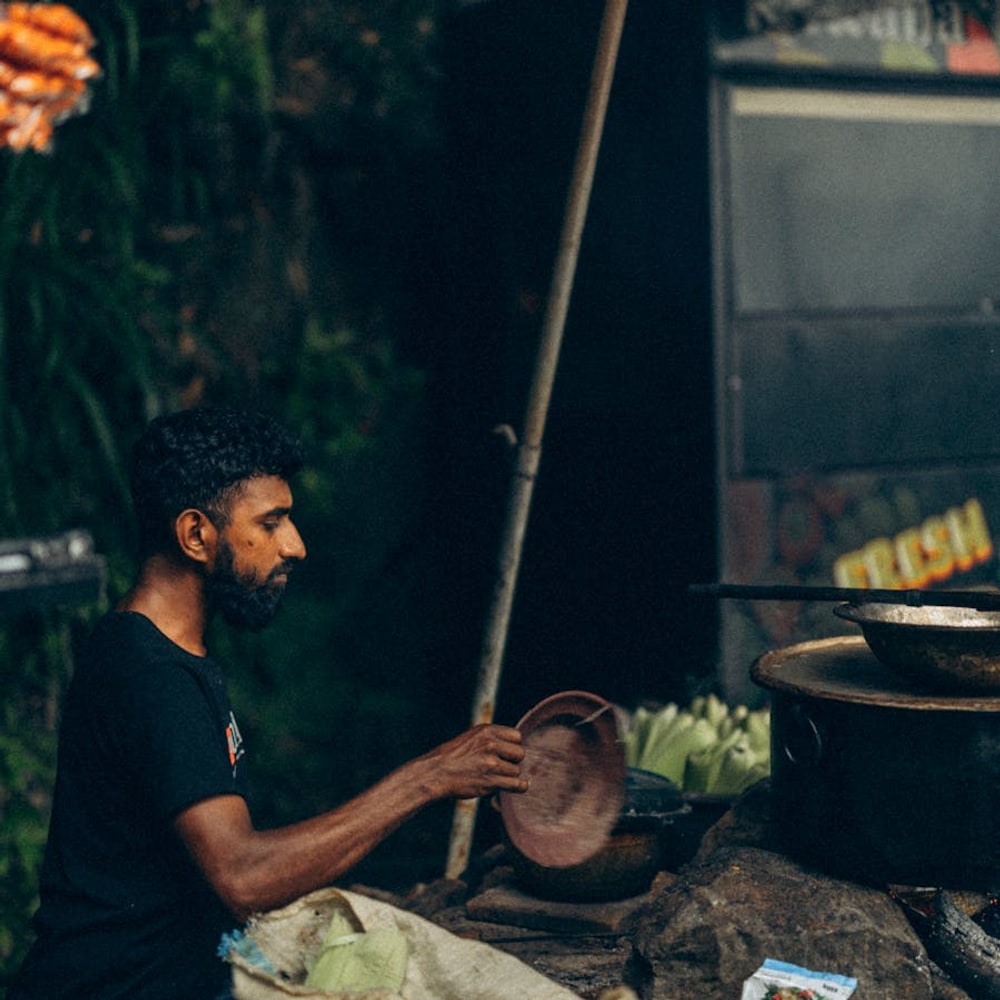 Street vendor cooking traditional food at a busy Sri Lanka market stall