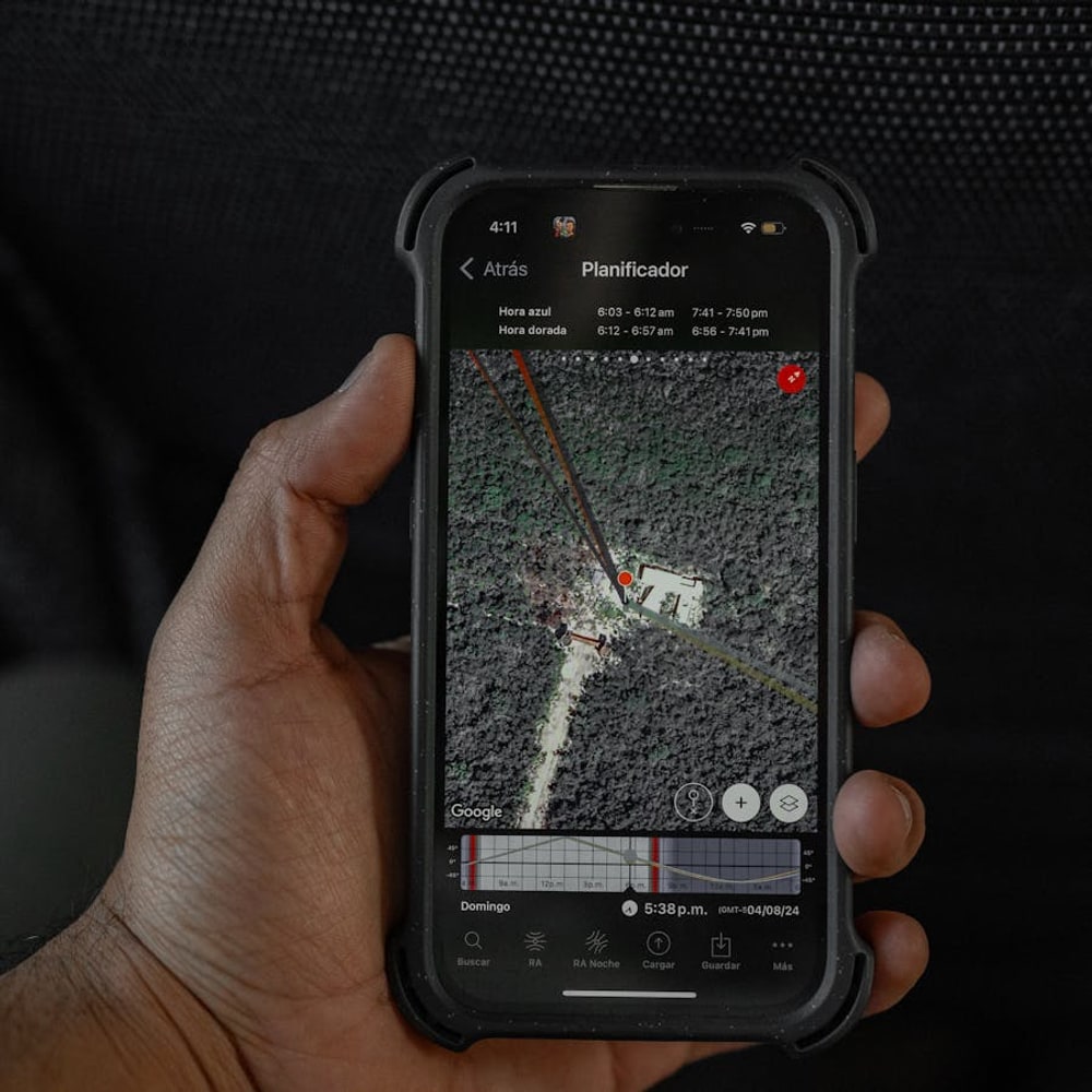 Hand holding a smartphone displaying a GPS navigation map for route planning