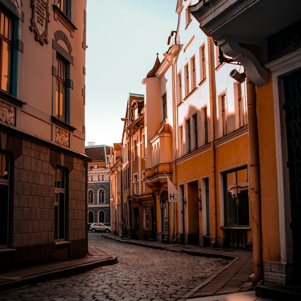 Sunny cobblestone street between old buildings in a popular seasonal destination