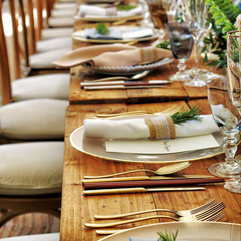 Table spread with breakfast dishes, bread, fruit, and coffee in morning light