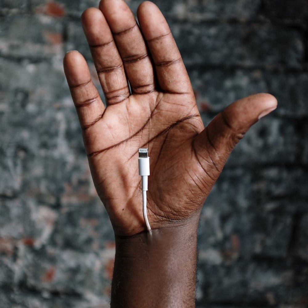 Close-up of a hand holding a USB charging cable for powering devices on the go