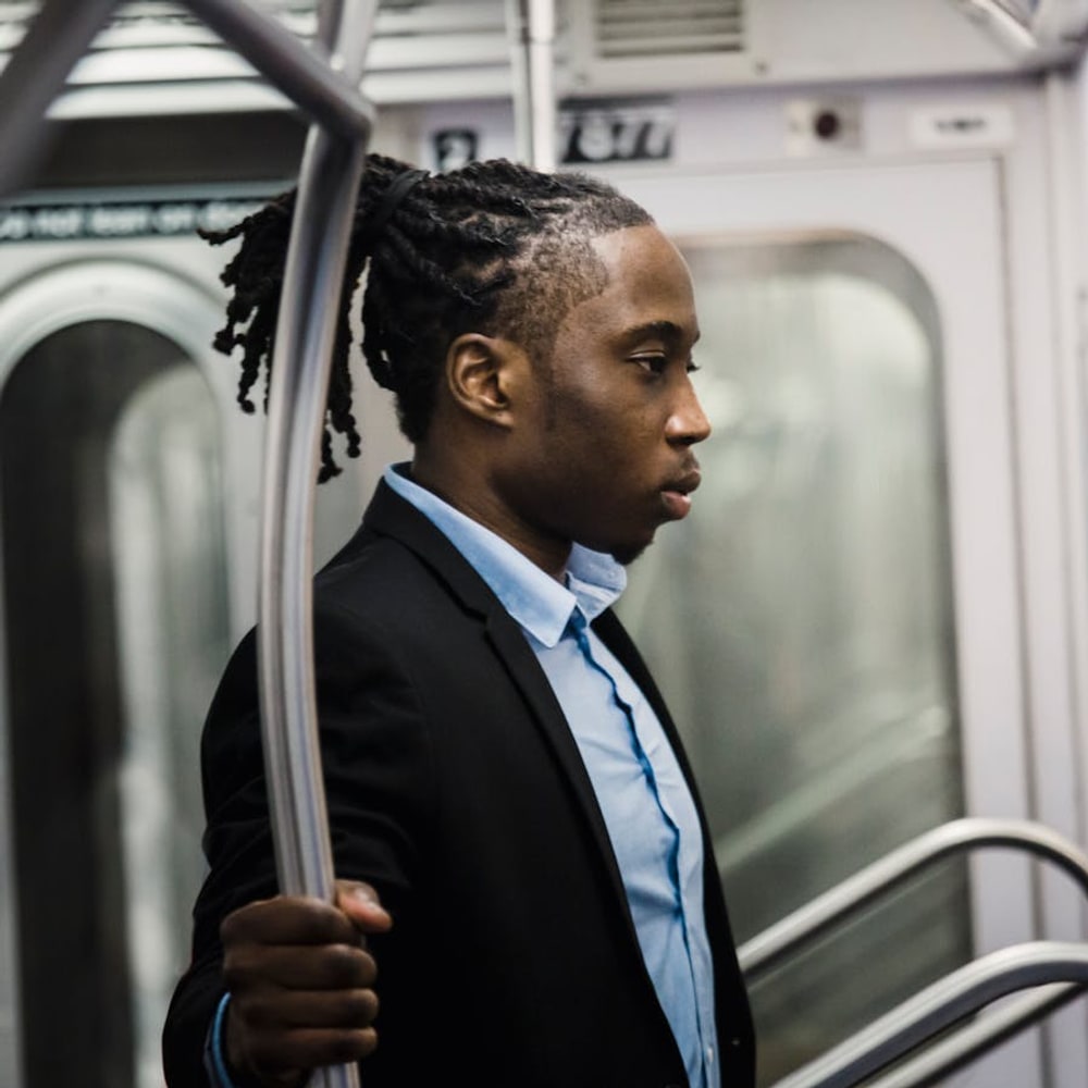 Tired solo commuter standing on a subway train during a long travel day