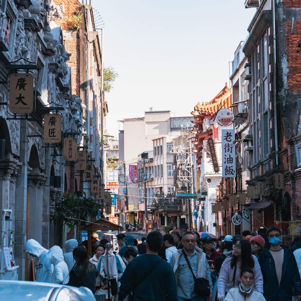 Bustling Asian street market with traditional architecture and crowded vendor stalls