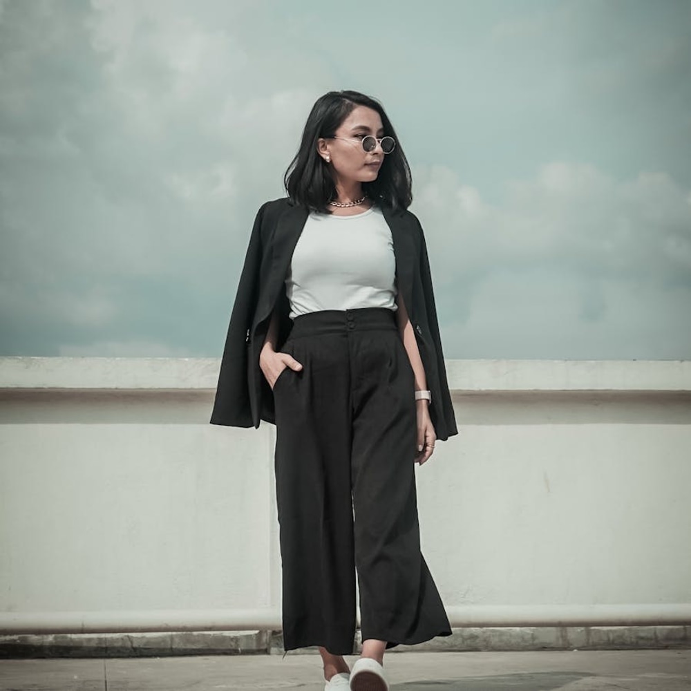 Stylish woman in a modern casual travel outfit walking on a city pavement