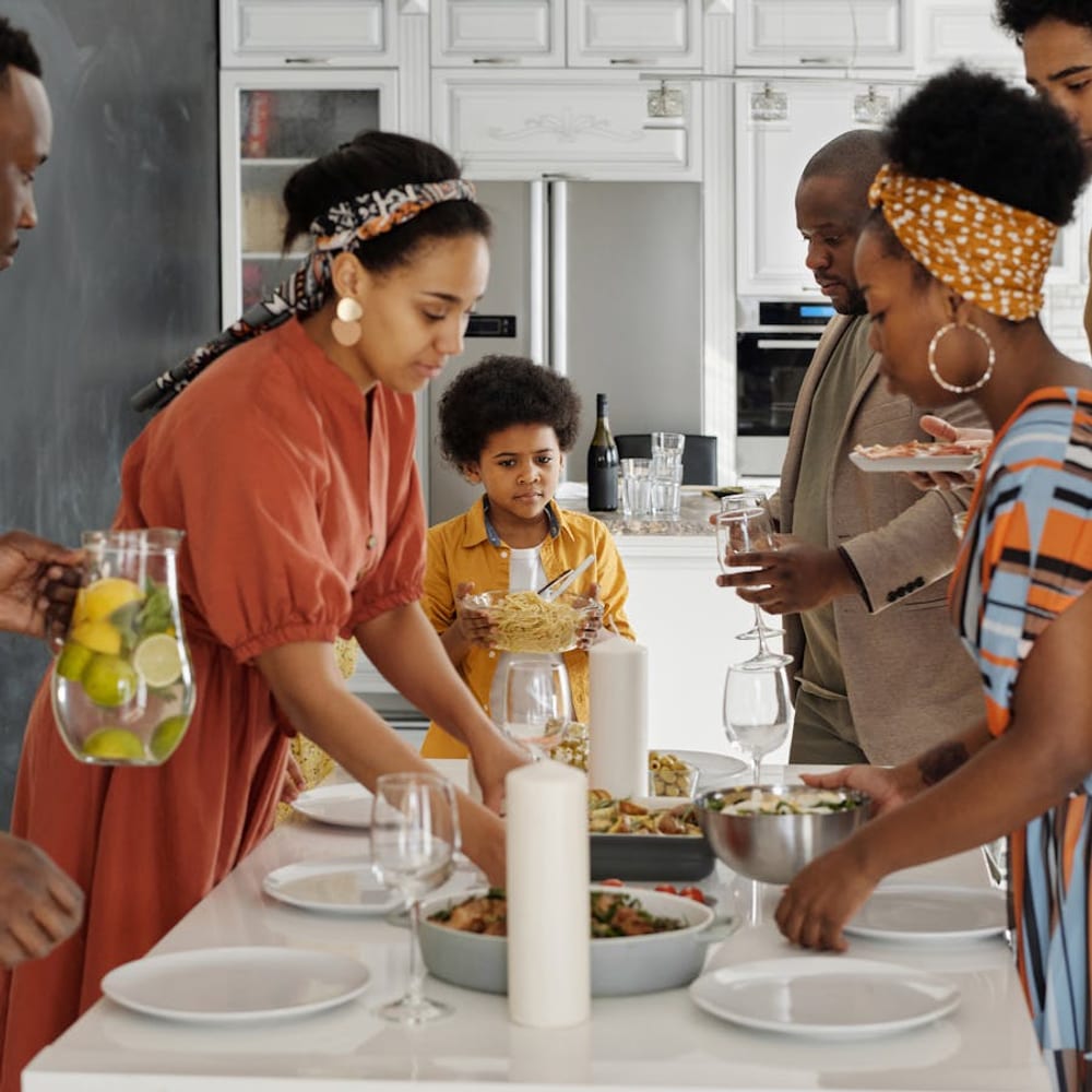 Family members setting the dining table together before an evening meal at home