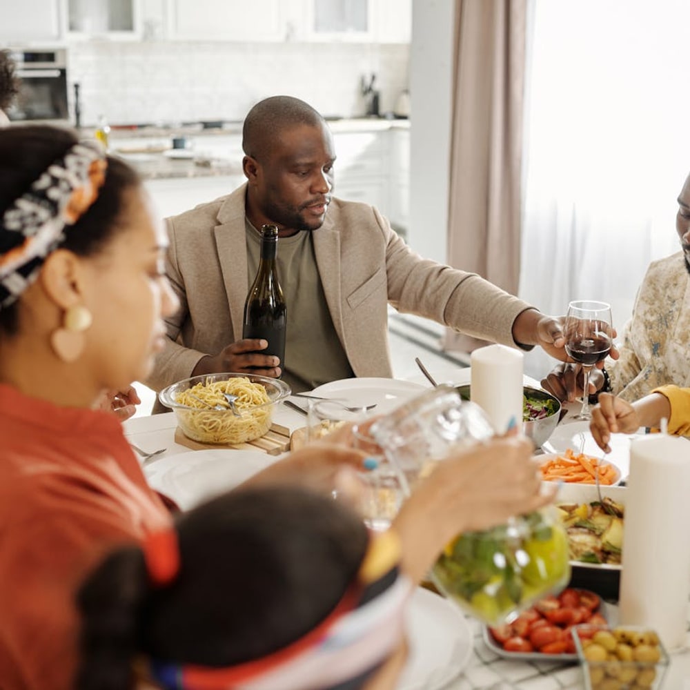 Family gathered around a dinner table sharing a home-cooked meal together